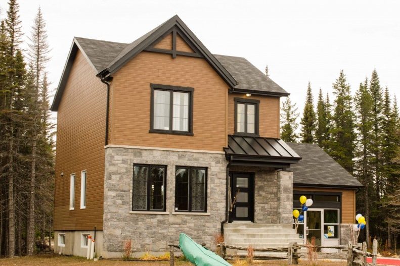 Cottage de pierre et de bois parmi les conifères, projet Falaise sur Mer à Sept-Îles